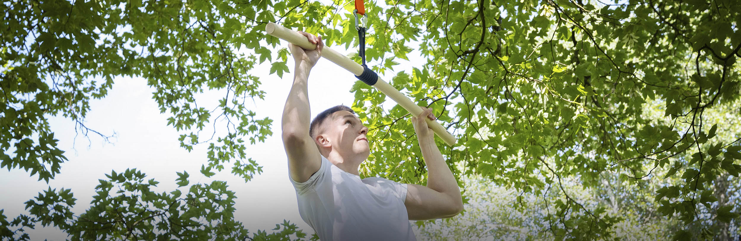 Person im Freien macht an der Klimmzugstange einen Klimmzug
